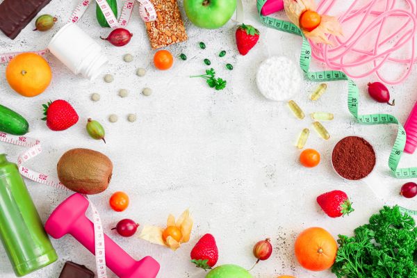 Sports nutrition and fitness accessories on a cement background. Sports nutrition and fitness accessories on a cement background.